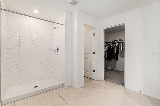 full bath featuring a stall shower, baseboards, visible vents, tile patterned floors, and a spacious closet