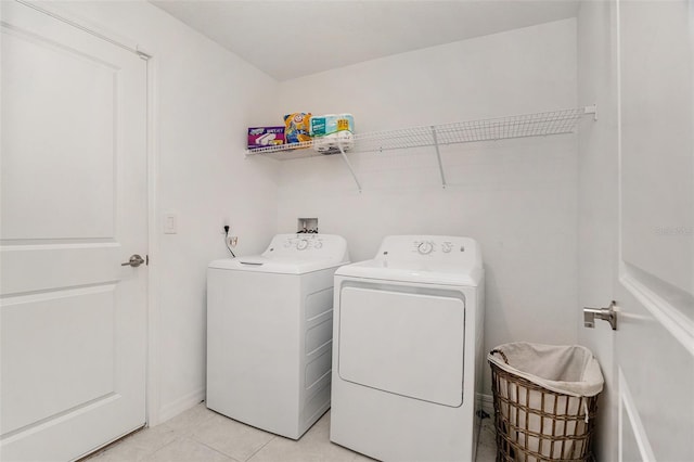 clothes washing area featuring light tile patterned floors, laundry area, and separate washer and dryer