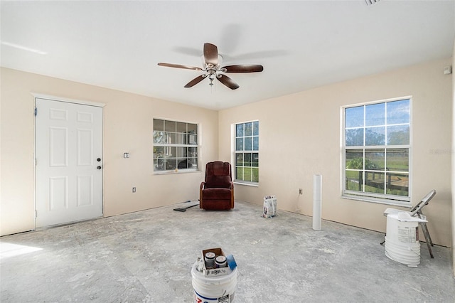 unfurnished room with ceiling fan and unfinished concrete floors