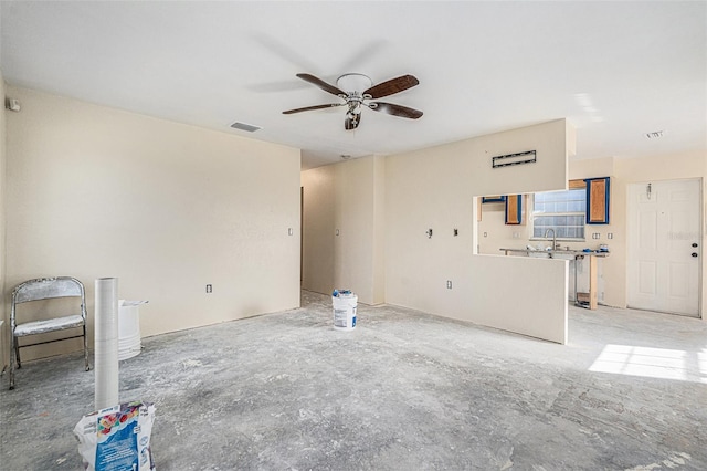 unfurnished living room with a ceiling fan, visible vents, and a sink