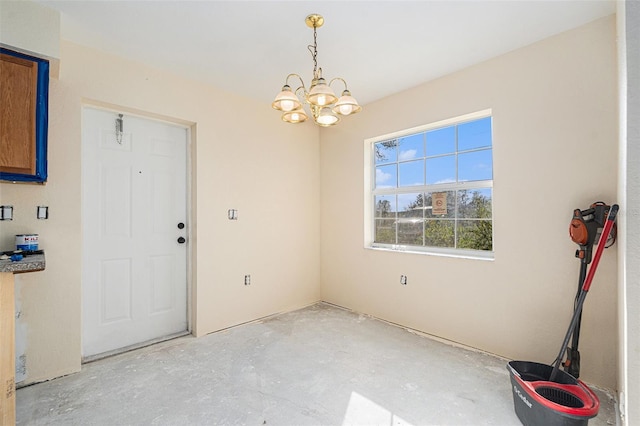 unfurnished dining area with concrete floors and a chandelier