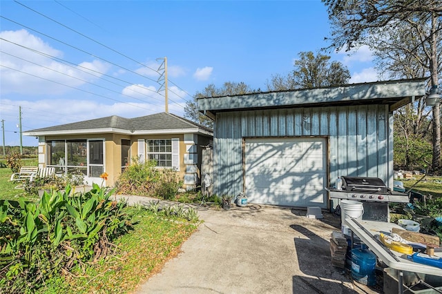 exterior space with an outdoor structure, driveway, and a detached garage