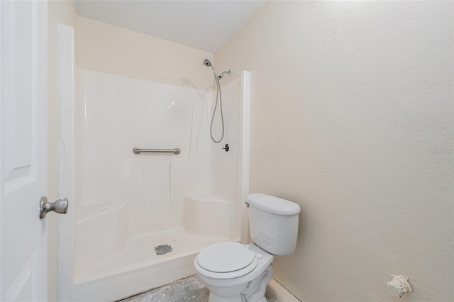 bathroom featuring toilet and a shower