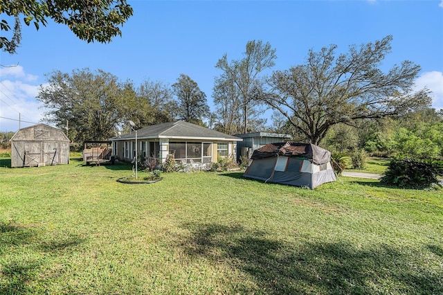 view of yard with a sunroom, a shed, and an outdoor structure