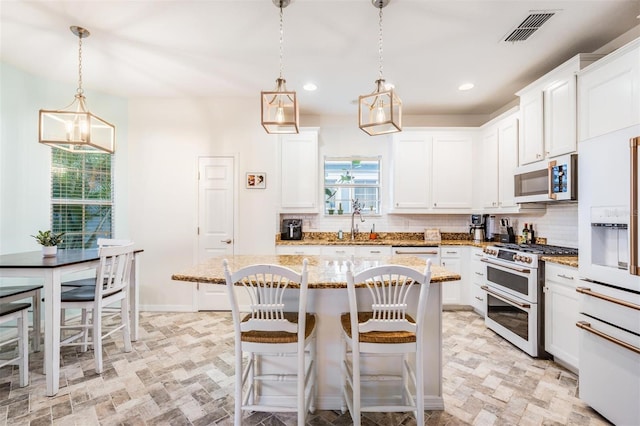 kitchen with tasteful backsplash, visible vents, white microwave, light stone countertops, and double oven range