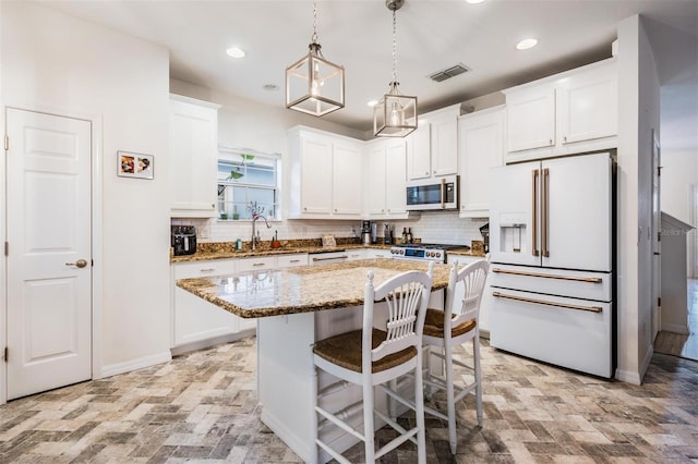 kitchen with visible vents, white cabinets, high end white fridge, light stone countertops, and stainless steel microwave