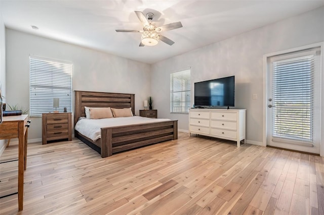 bedroom with access to exterior, light wood-style flooring, multiple windows, and baseboards