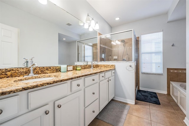 full bathroom featuring double vanity, a stall shower, a sink, and tile patterned floors