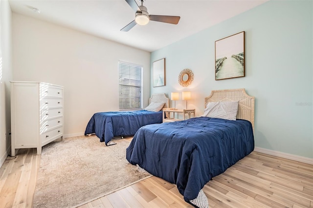 bedroom featuring light wood finished floors, baseboards, and a ceiling fan