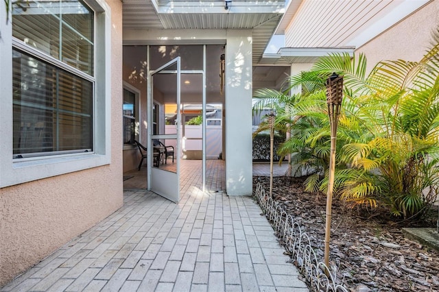 property entrance featuring a patio area and stucco siding