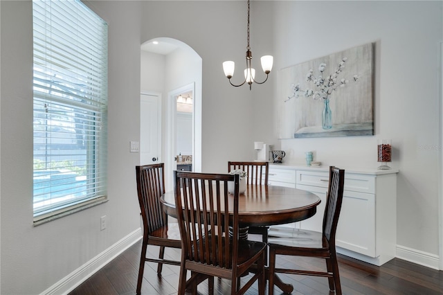 dining room with dark wood-style floors, arched walkways, plenty of natural light, and baseboards