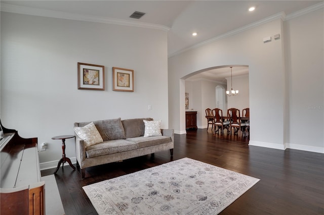 living room with arched walkways, visible vents, baseboards, dark wood finished floors, and crown molding