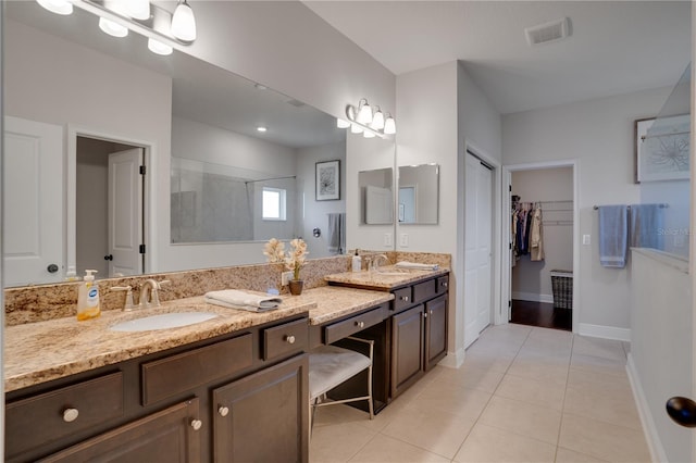 full bathroom with visible vents, walk in shower, a sink, and tile patterned floors