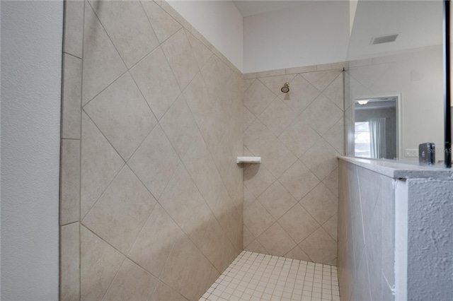 bathroom featuring visible vents and tiled shower