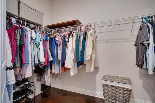 walk in closet with wood finished floors