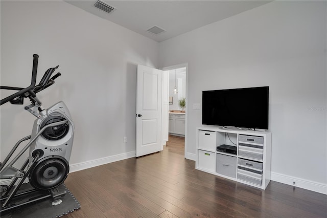 workout area featuring dark wood-style floors, visible vents, and baseboards