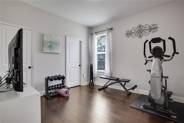 exercise area featuring baseboards and wood finished floors