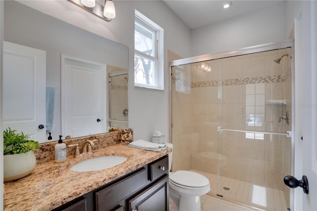 full bathroom featuring toilet, a shower stall, and vanity