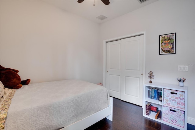 bedroom featuring ceiling fan, a closet, dark wood finished floors, and visible vents