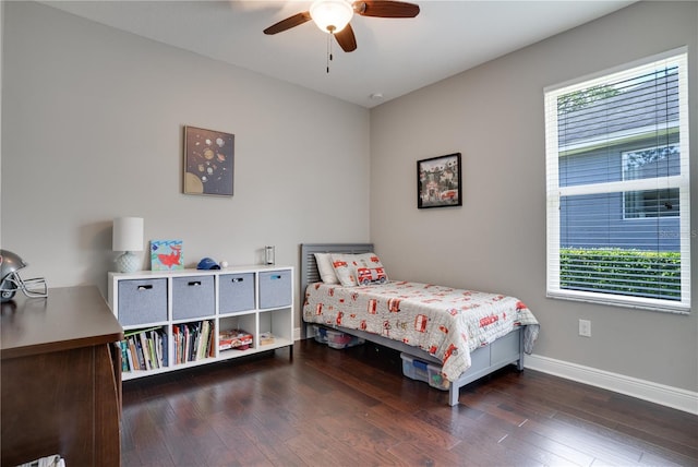 bedroom with ceiling fan, wood finished floors, and baseboards