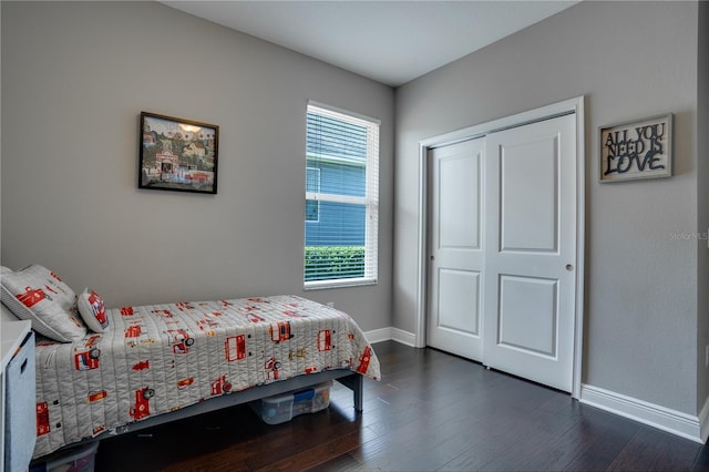 bedroom featuring a closet, baseboards, and dark wood-type flooring