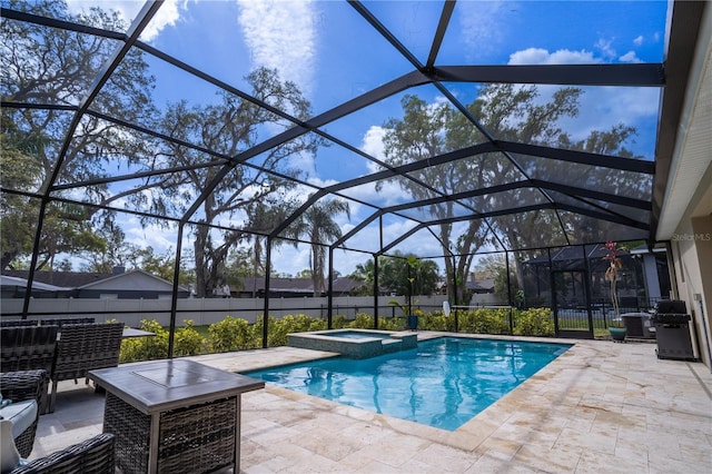 view of pool with a patio, glass enclosure, and a pool with connected hot tub