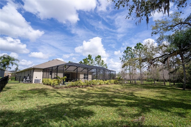 view of yard with glass enclosure, a fenced backyard, and central air condition unit