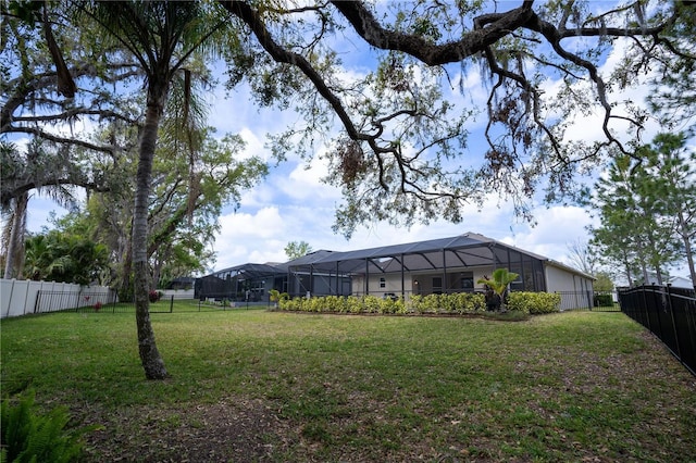 view of yard featuring glass enclosure and a fenced backyard