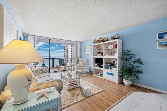 living area featuring baseboards, a textured ceiling, and wood finished floors