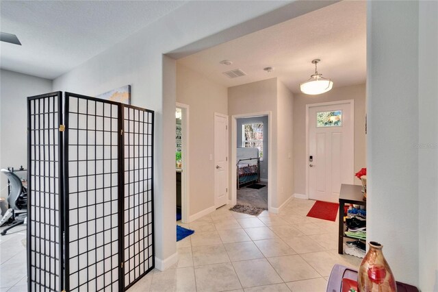 entrance foyer featuring light tile patterned floors, visible vents, and baseboards