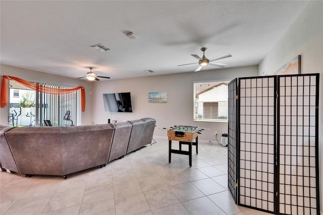 living room featuring plenty of natural light, a ceiling fan, and visible vents
