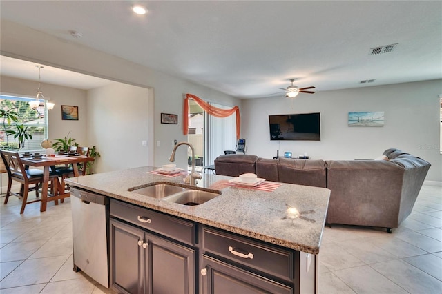 kitchen featuring a ceiling fan, visible vents, a center island with sink, a sink, and dishwasher