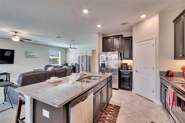 kitchen with visible vents, open floor plan, stainless steel appliances, a ceiling fan, and a sink