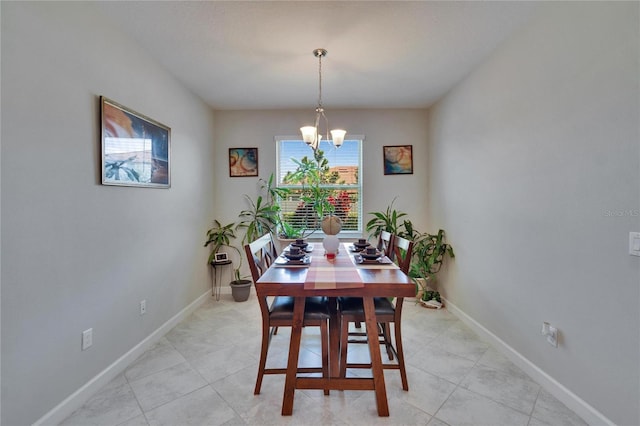 dining room with light tile patterned floors, baseboards, and a chandelier