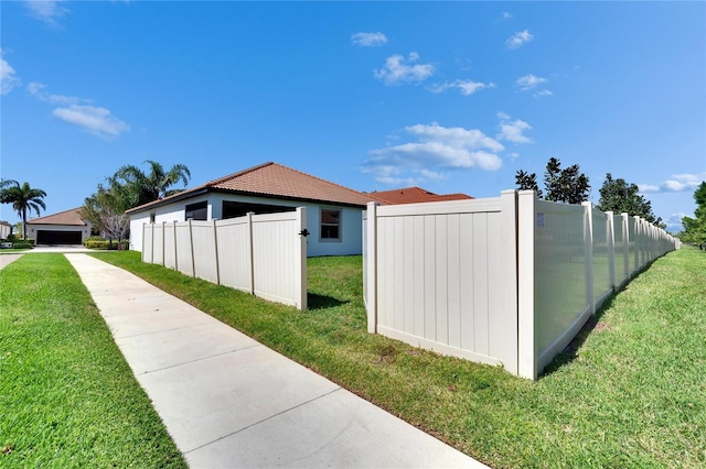 view of home's exterior featuring fence and a lawn