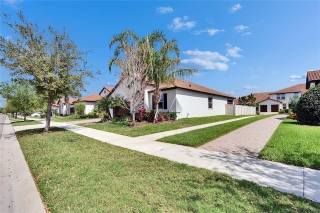 view of front of home featuring stucco siding, a front yard, and fence