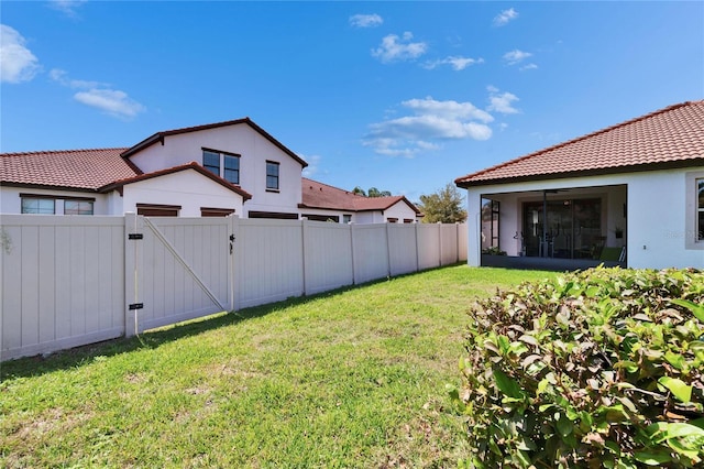 view of yard with a fenced backyard and a gate