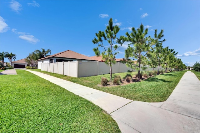 view of home's community with a yard and fence