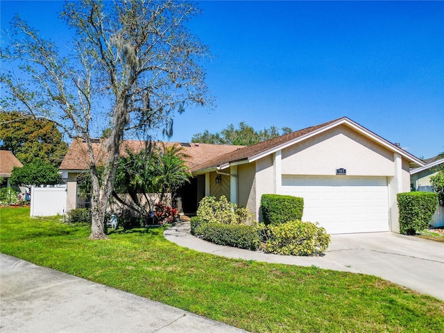 ranch-style home with stucco siding, concrete driveway, an attached garage, fence, and a front lawn