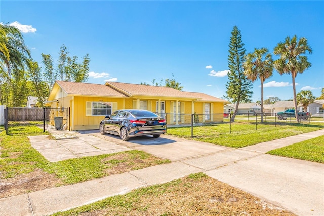 ranch-style home with driveway, a front yard, fence private yard, and a gate