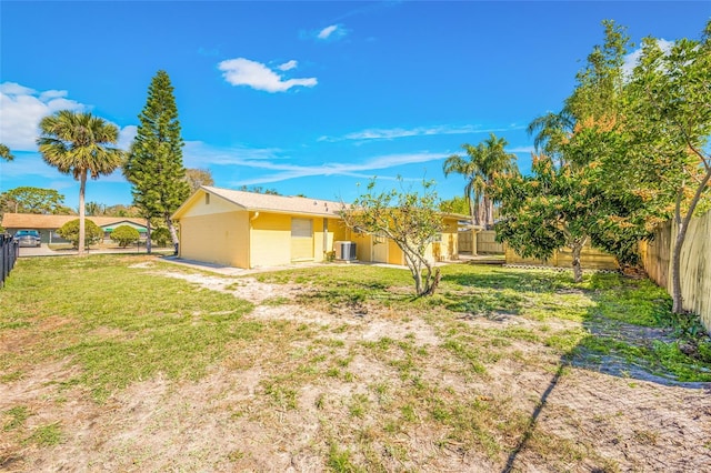 view of yard with a fenced backyard and central AC unit