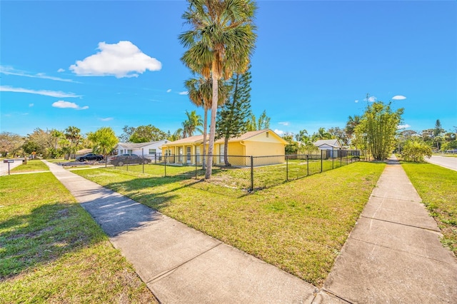 view of home's community with a yard and fence