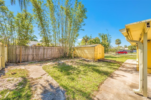 view of yard with a fenced backyard, an outdoor structure, and a shed