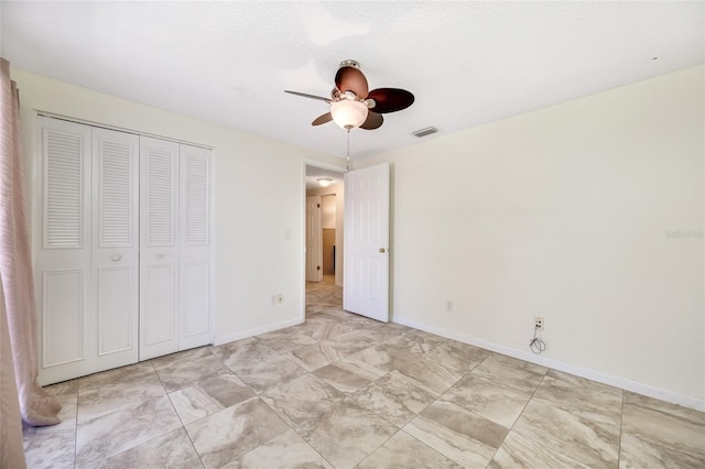 unfurnished bedroom featuring a textured ceiling, a ceiling fan, visible vents, baseboards, and a closet