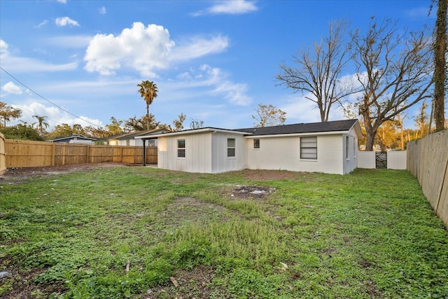 rear view of property featuring a fenced backyard and a yard