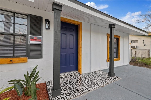 property entrance featuring a porch and concrete block siding