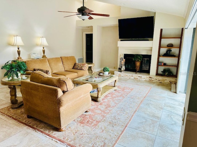 living area with tile patterned floors, visible vents, a glass covered fireplace, ceiling fan, and vaulted ceiling