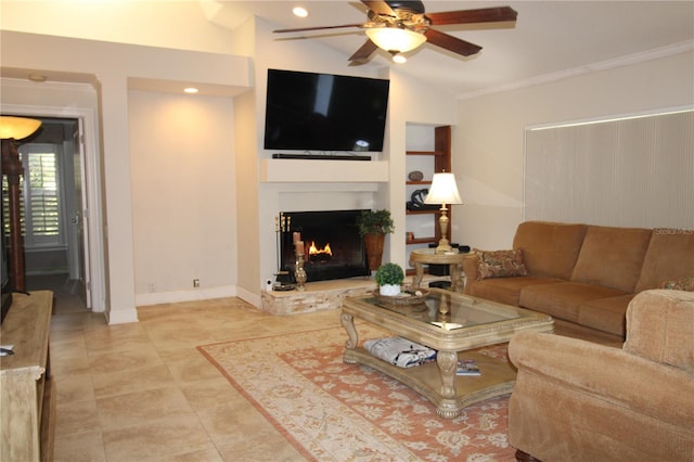 living area featuring a ceiling fan, a lit fireplace, crown molding, baseboards, and vaulted ceiling