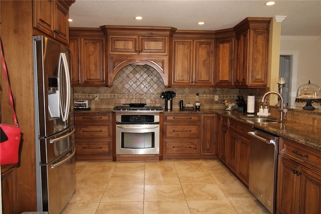 kitchen featuring brown cabinetry, appliances with stainless steel finishes, tasteful backsplash, and a sink