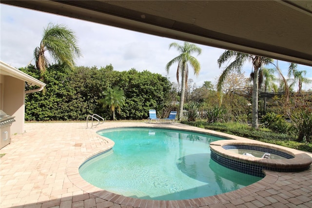 view of swimming pool featuring a patio and a pool with connected hot tub